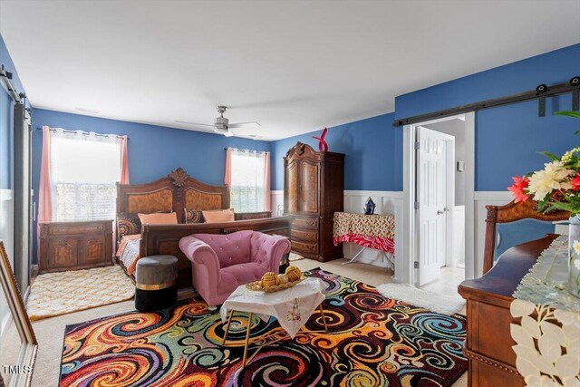 6001 Winged Willet Ct, Wendell, NC 27591 - carpeted bedroom with wainscoting, a ceiling fan, and a barn door