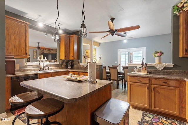 6001 Winged Willet Ct, Wendell, NC 27591 - kitchen featuring ceiling fan, black dishwasher, a peninsula, brown cabinetry, and a breakfast bar area