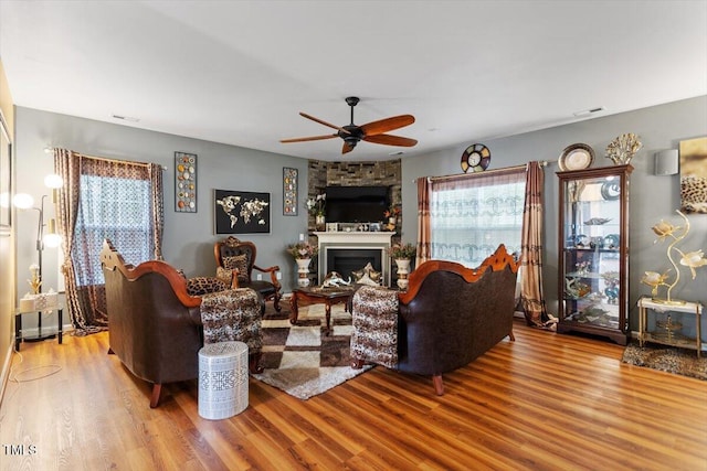6001 Winged Willet Ct, Wendell, NC 27591 - living area featuring wood finished floors, a ceiling fan, and a large fireplace