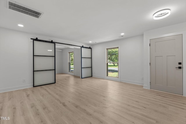 620 Red Carriage Ave, Durham, NC 27704 - spare room featuring a barn door, light wood-type flooring, and recessed lighting