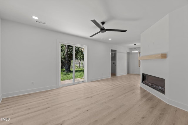 620 Red Carriage Ave, Durham, NC 27704 - unfurnished living room featuring ceiling fan, light wood-style floors, a glass covered fireplace, and recessed lighting
