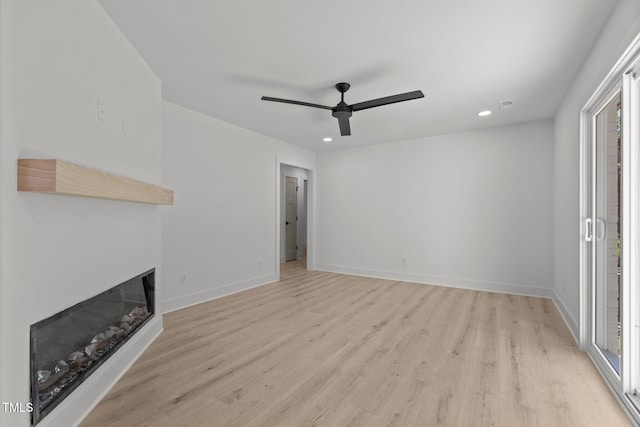 620 Red Carriage Ave, Durham, NC 27704 - unfurnished living room with a ceiling fan, light wood-style floors, healthy amount of natural light, a glass covered fireplace, and recessed lighting