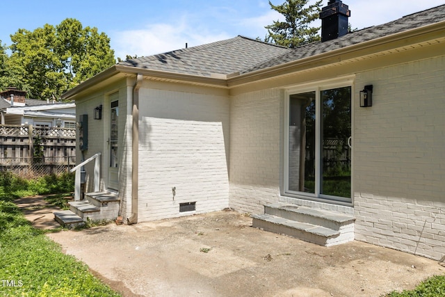 620 Red Carriage Ave, Durham, NC 27704 - view of home's exterior featuring brick siding, entry steps, a patio, and a chimney
