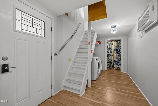3516 Swift Dr, Raleigh, NC 27606 - foyer with washing machine and clothes dryer, an AC wall unit, stairway, and light wood finished floors