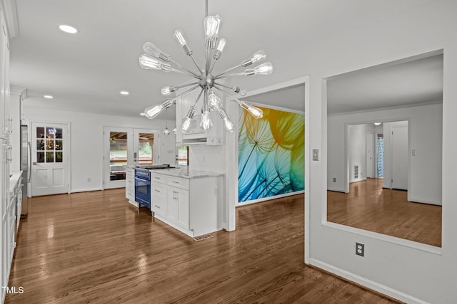 3516 Swift Dr, Raleigh, NC 27606 - kitchen featuring gas range, a chandelier, white cabinets, wood finished floors, and hanging light fixtures