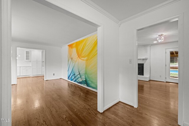 3516 Swift Dr, Raleigh, NC 27606 - unfurnished living room with wood finished floors, crown molding, and a brick fireplace