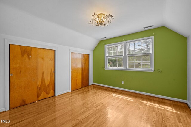 3516 Swift Dr, Raleigh, NC 27606 - unfurnished bedroom featuring lofted ceiling, multiple closets, and wood finished floors