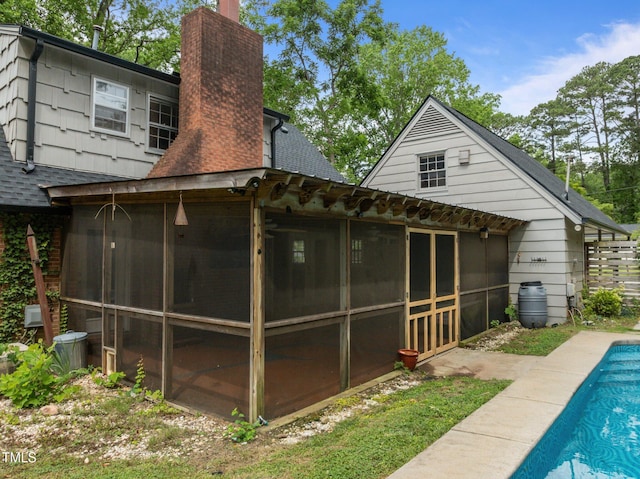 3516 Swift Dr, Raleigh, NC 27606 - back of property with a sunroom, a chimney, and roof with shingles
