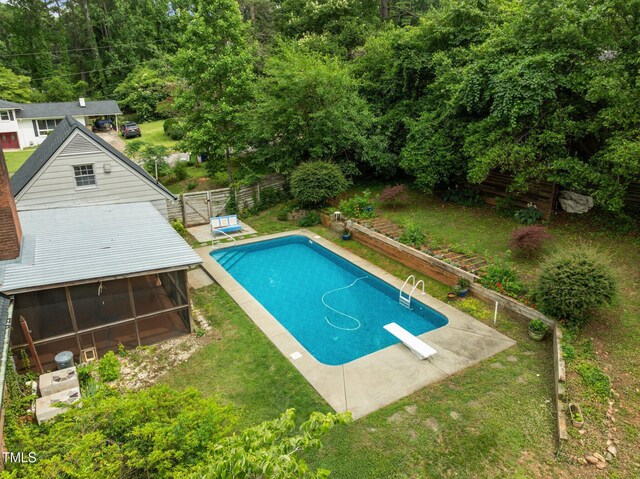 3516 Swift Dr, Raleigh, NC 27606 - swimming pool with a sunroom, a fenced backyard, a diving board, and view of wooded area