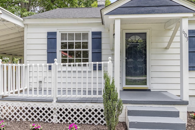 603 S Third St, Mebane, NC 27302 - view of exterior entry with a shingled roof, a chimney, and a deck