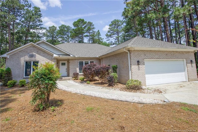 38 Windsong Pl, Whispering Pines, NC 28327 - view of front of house featuring a garage, concrete driveway, brick siding, and roof with shingles