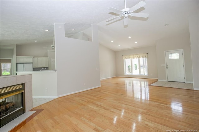 38 Windsong Pl, Whispering Pines, NC 28327 - unfurnished living room with ceiling fan, high vaulted ceiling, light wood-style flooring, recessed lighting, and a tiled fireplace