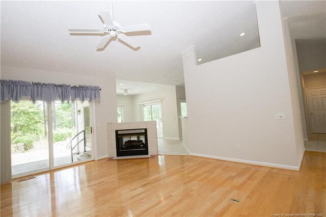 38 Windsong Pl, Whispering Pines, NC 28327 - unfurnished living room featuring light wood-style floors, ceiling fan, and a tile fireplace