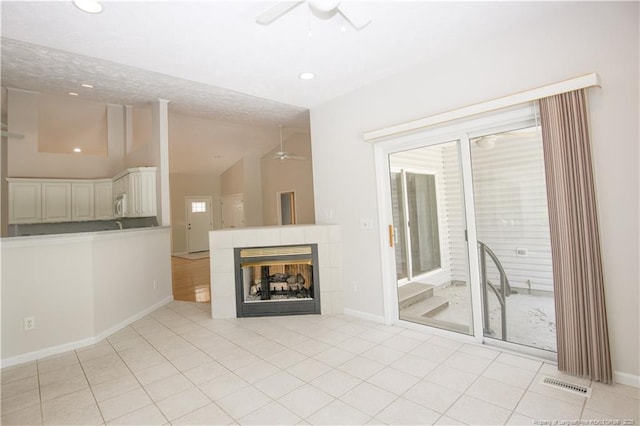 38 Windsong Pl, Whispering Pines, NC 28327 - unfurnished living room with ceiling fan, lofted ceiling, light tile patterned flooring, recessed lighting, and a tile fireplace
