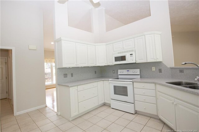 38 Windsong Pl, Whispering Pines, NC 28327 - kitchen with white appliances, high vaulted ceiling, tasteful backsplash, and light countertops