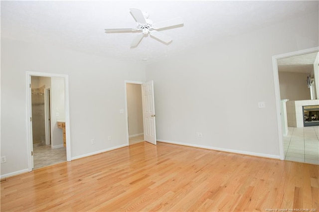 38 Windsong Pl, Whispering Pines, NC 28327 - unfurnished living room with light wood finished floors, a ceiling fan, and a tile fireplace