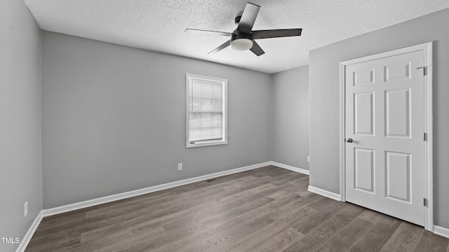 427 Elm Ct, Burlington, NC 27217 - unfurnished bedroom featuring dark wood finished floors, a textured ceiling, and a ceiling fan