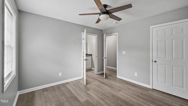 427 Elm Ct, Burlington, NC 27217 - unfurnished bedroom with wood finished floors, a textured ceiling, and ceiling fan