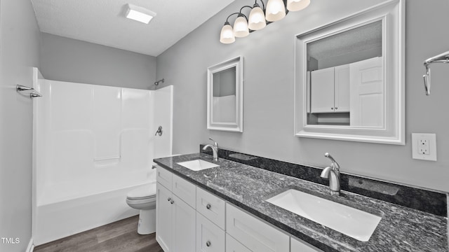 427 Elm Ct, Burlington, NC 27217 - full bathroom featuring double vanity, wood finished floors, shower / tub combination, and a textured ceiling