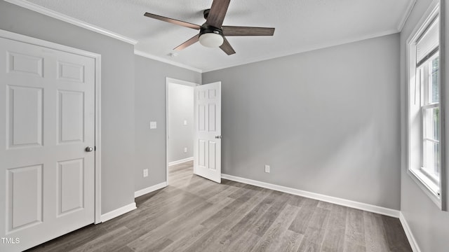 427 Elm Ct, Burlington, NC 27217 - unfurnished bedroom featuring wood finished floors, multiple windows, ornamental molding, and ceiling fan