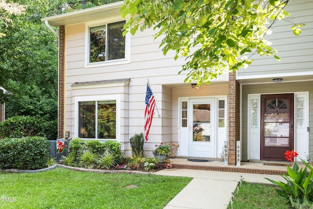 6021 Dixon Dr, Raleigh, NC 27609 - view of exterior entry with a yard and brick siding