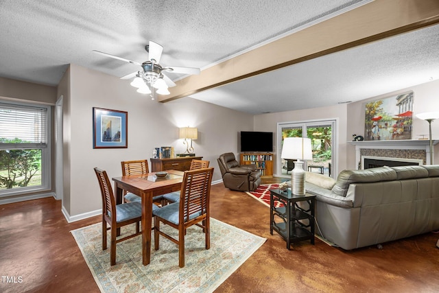 6021 Dixon Dr, Raleigh, NC 27609 - dining room with finished concrete floors, a textured ceiling, ceiling fan, a fireplace, and beam ceiling