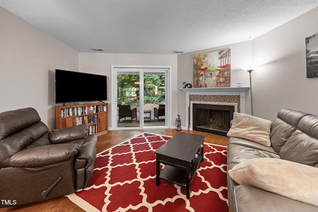 6021 Dixon Dr, Raleigh, NC 27609 - living area featuring a textured ceiling, a tiled fireplace, and wood finished floors