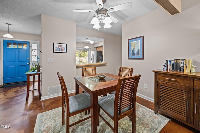 6021 Dixon Dr, Raleigh, NC 27609 - dining area featuring finished concrete floors, a ceiling fan, and a textured ceiling