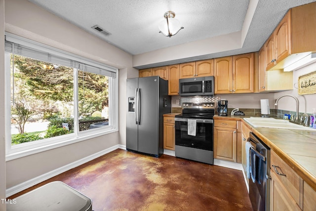 6021 Dixon Dr, Raleigh, NC 27609 - kitchen with appliances with stainless steel finishes, finished concrete floors, tile counters, a textured ceiling, and decorative backsplash