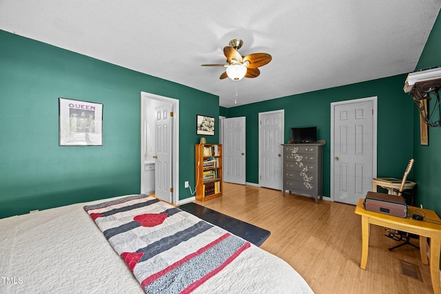 6021 Dixon Dr, Raleigh, NC 27609 - bedroom with wood finished floors, a ceiling fan, ensuite bathroom, two closets, and a textured ceiling