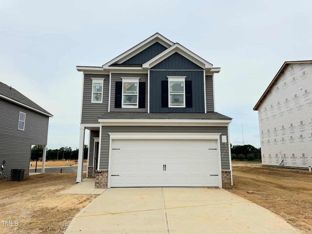 120 Bruce Dr, Dunn, NC 28334 - view of front of property with board and batten siding, a garage, driveway, and brick siding
