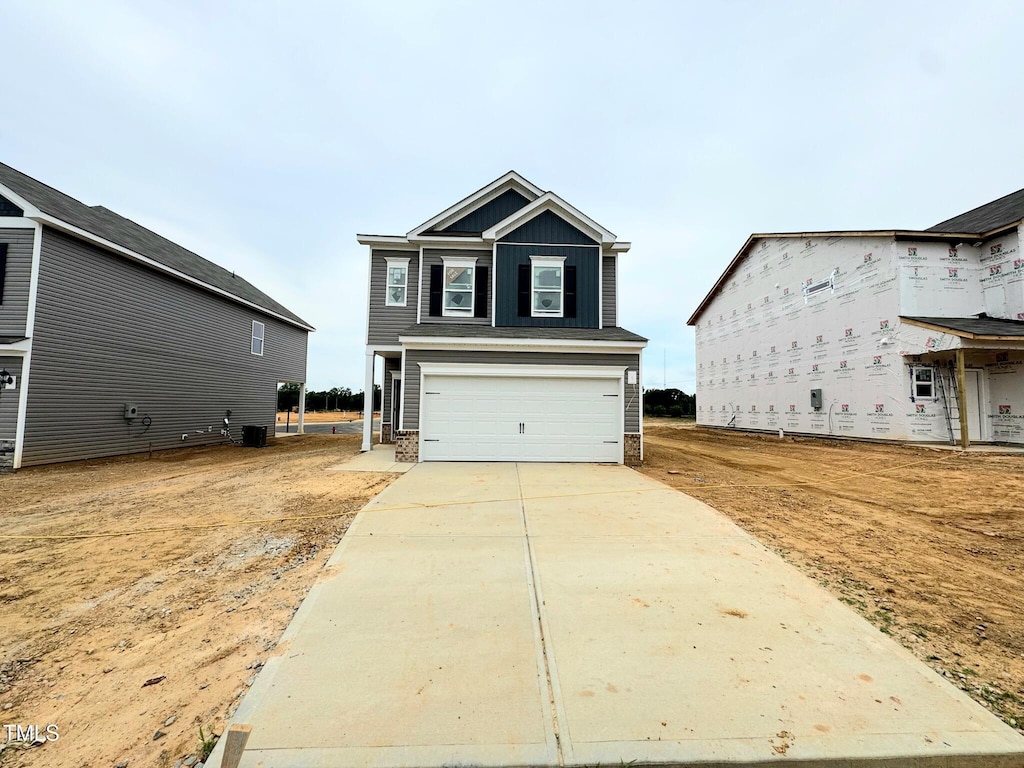 120 Bruce Dr, Dunn, NC 28334 - view of front facade with an attached garage, concrete driveway, and board and batten siding