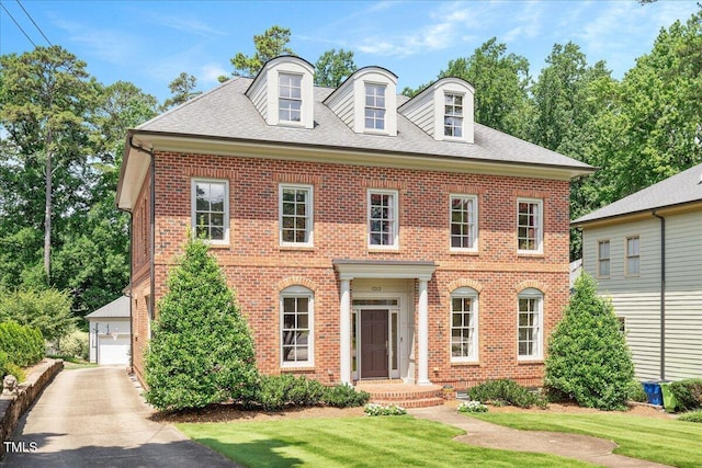 1313 Duplin Rd, Raleigh, NC 27607 - colonial home featuring brick siding, a front lawn, a shingled roof, and a detached garage
