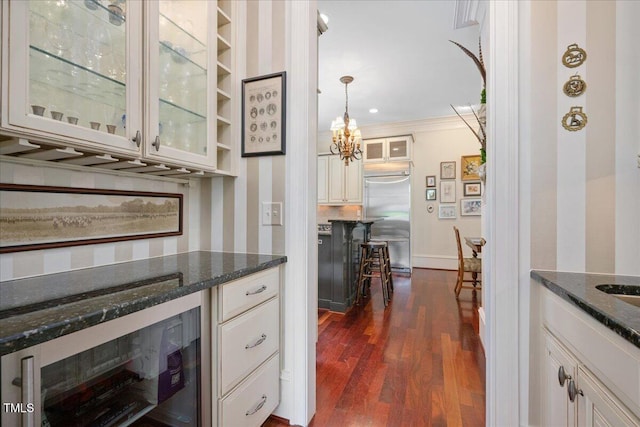 1313 Duplin Rd, Raleigh, NC 27607 - bar area featuring wine cooler, built in refrigerator, dark wood-style flooring, a chandelier, and ornamental molding