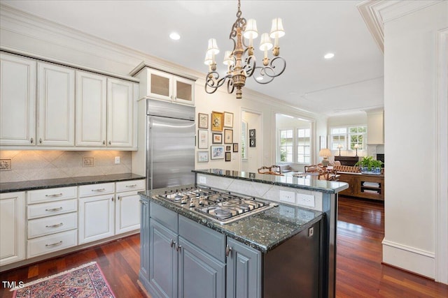 1313 Duplin Rd, Raleigh, NC 27607 - kitchen featuring appliances with stainless steel finishes, crown molding, a center island, dark wood finished floors, and decorative backsplash
