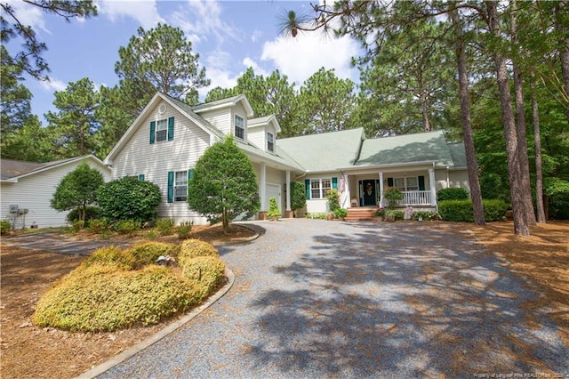 957 Blackeyed Susan Pl, Vass, NC 28394 - view of front facade featuring covered porch, gravel driveway, and an attached garage