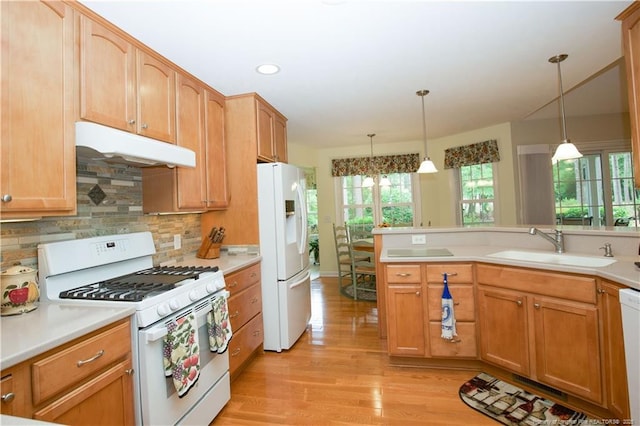 957 Blackeyed Susan Pl, Vass, NC 28394 - kitchen featuring white appliances, under cabinet range hood, light wood finished floors, tasteful backsplash, and decorative light fixtures