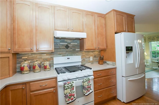 957 Blackeyed Susan Pl, Vass, NC 28394 - kitchen featuring white appliances, under cabinet range hood, light countertops, light wood-style flooring, and tasteful backsplash