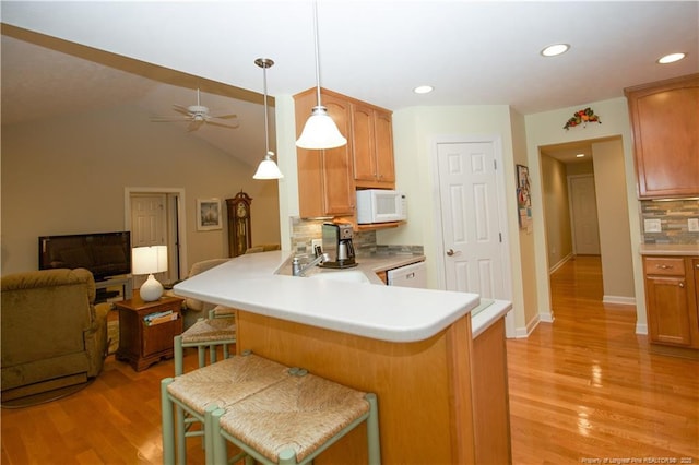 957 Blackeyed Susan Pl, Vass, NC 28394 - kitchen featuring white appliances, tasteful backsplash, open floor plan, a peninsula, and light wood-style floors