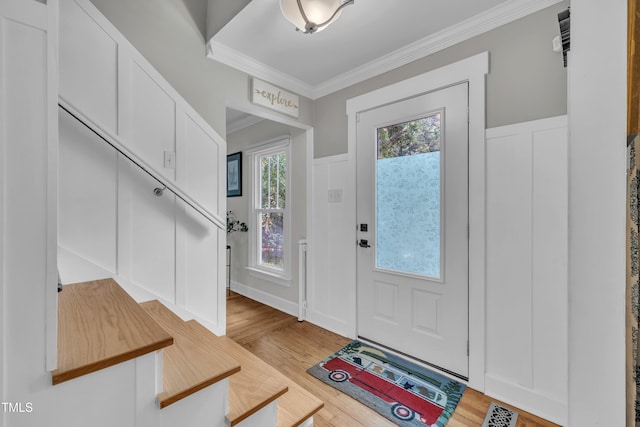 7917 Featherstone Dr, Raleigh, NC 27615 - foyer featuring wood finished floors, crown molding, a decorative wall, stairway, and a wainscoted wall