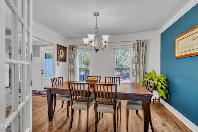 7917 Featherstone Dr, Raleigh, NC 27615 - dining space featuring light wood finished floors, a chandelier, and crown molding