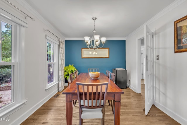 7917 Featherstone Dr, Raleigh, NC 27615 - dining area with a chandelier, ornamental molding, and light wood-type flooring