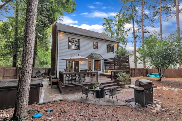 7917 Featherstone Dr, Raleigh, NC 27615 - rear view of house featuring a hot tub, a fenced backyard, a patio, a deck, and a fire pit