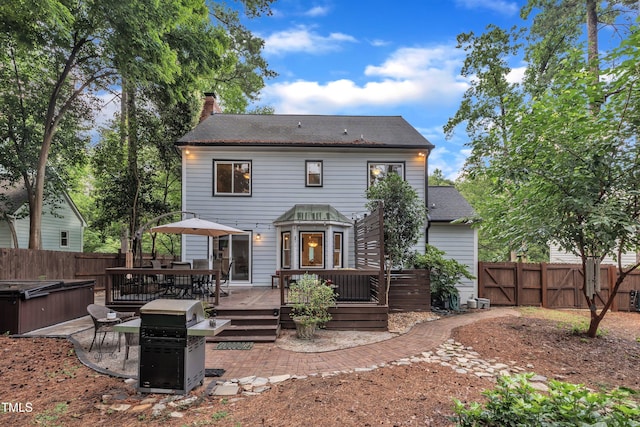 7917 Featherstone Dr, Raleigh, NC 27615 - back of property featuring a wooden deck, a fenced backyard, a chimney, and a hot tub