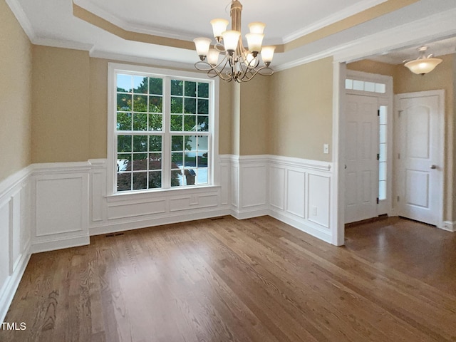 1201 Dagmar Ln, Wake Forest, NC 27587 - unfurnished dining area with ornamental molding, a chandelier, a wainscoted wall, wood finished floors, and a tray ceiling