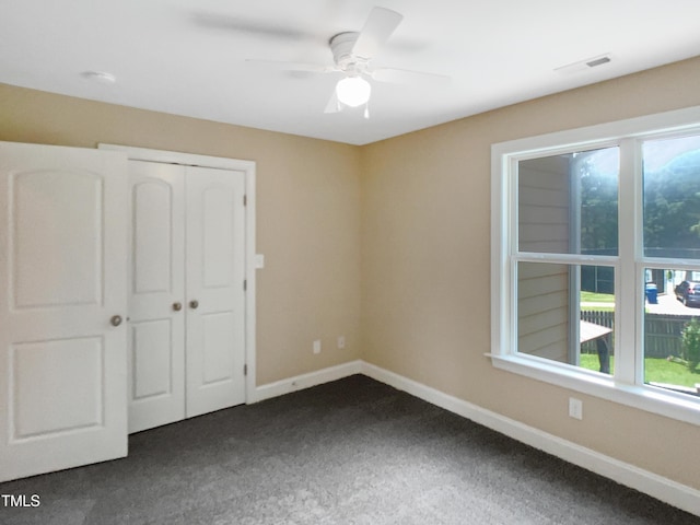 1201 Dagmar Ln, Wake Forest, NC 27587 - unfurnished bedroom with dark colored carpet, a closet, and a ceiling fan