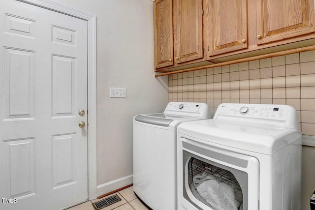116 Twin Oaks Pl, Goldsboro, NC 27530 - washroom featuring separate washer and dryer, cabinet space, and light tile patterned flooring