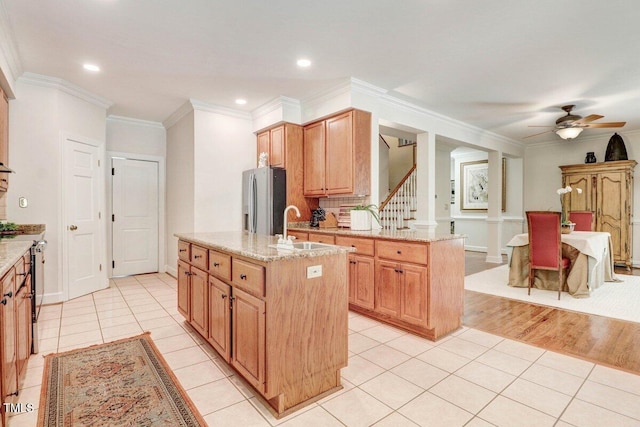 116 Twin Oaks Pl, Goldsboro, NC 27530 - kitchen with stainless steel refrigerator with ice dispenser, a kitchen island with sink, ceiling fan, light tile patterned flooring, and light stone counters