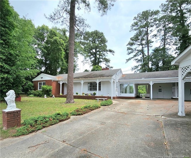 2943 Ole Bluff Mill Rd, Fayetteville, NC 28306 - view of front of house with a front yard, a carport, driveway, and a chimney