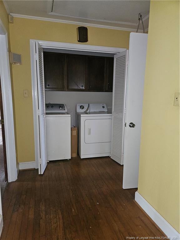 2943 Ole Bluff Mill Rd, Fayetteville, NC 28306 - washroom with cabinet space, dark wood-style flooring, washing machine and clothes dryer, and ornamental molding